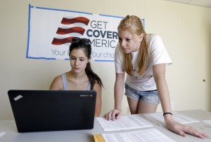 Ashley Hentze, left, of Lakeland, gets help signing up for health care from Kristen Nash, a volunteer with Enroll America, a private, non-profit organization running a grassroots campaign to encourage people to sign up for health care, Tuesday, Oct. 1, 2013, in Tampa [CREDIT: Chris O'Meara, for The Associated Press]