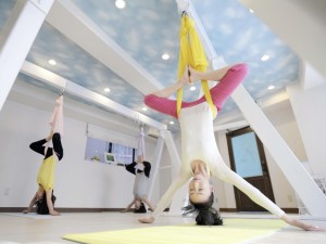 Manao, front, takes on an aerial yoga pose using a hammock; Manao first learned aerial yoga in 2011, and opened her own studio in Tokyo last year to help spread the exercise.  (The Japan News/Yomiuri).