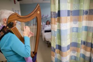 Jan Lucas plays the harp for patients in the emergency room at St. Joseph's Hospital in Paterson, N.J. Using opioids for pain only as a last resort, St. Joseph's now treats many pain patients with alternatives like laughing gas, trigger-point injections and even a therapy harp. Mark Makela/The New York Times